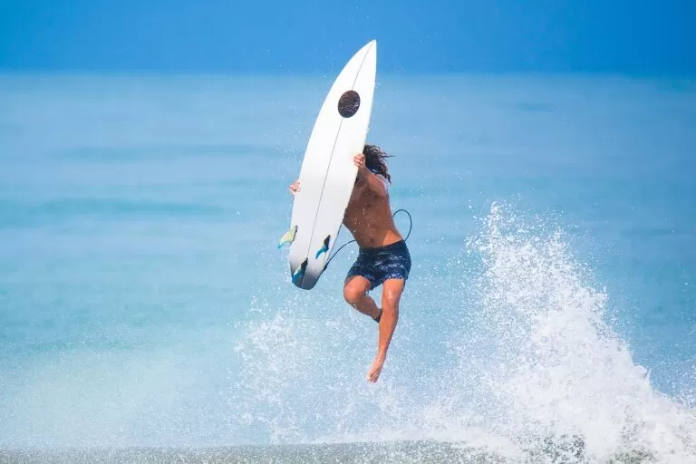 A surfer jumps on a wave